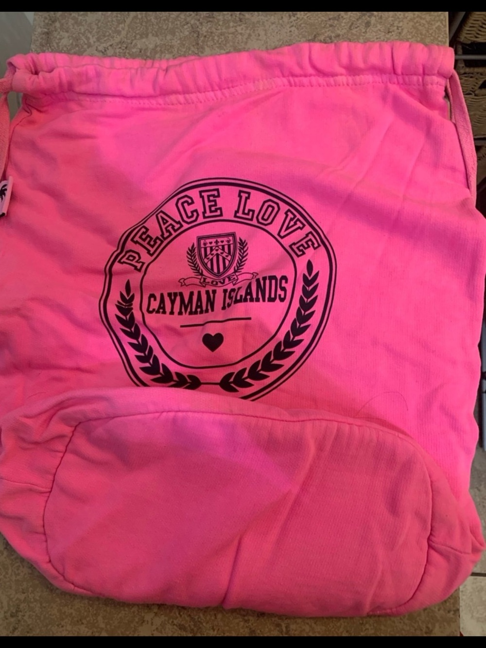 Bright Neon Pink Drawstring Bag features a "Peace Love Cayman Islands" graphic.